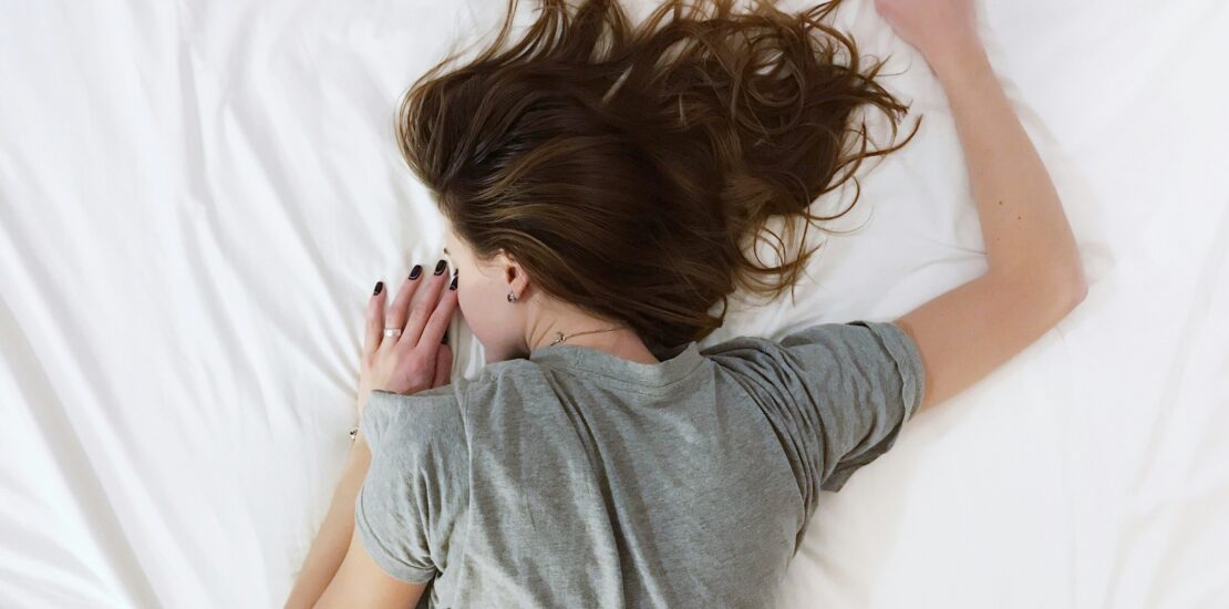 Erschöpfte Frau liegt im Bett