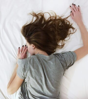 Erschöpfte Frau liegt im Bett